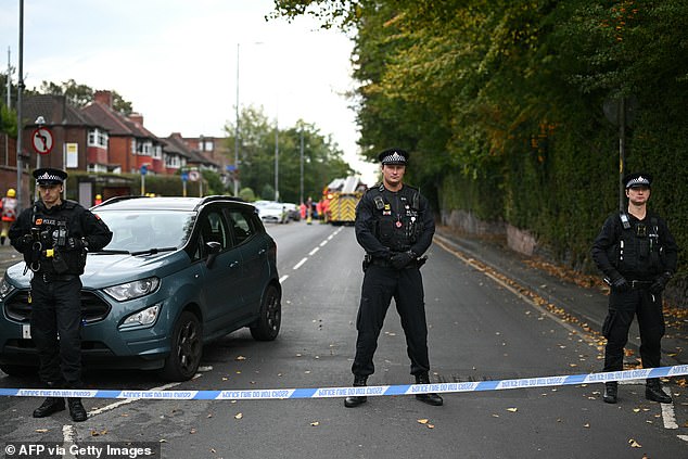 Police are seen standing guard outside the Heaton Park Hebrew Congregation synagogue
