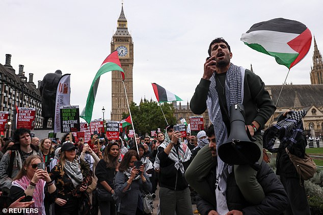A demonstrator speaks through a megaphone, as people gather in Parliament Square to protest and demand protection for the Global Sumud Flotilla