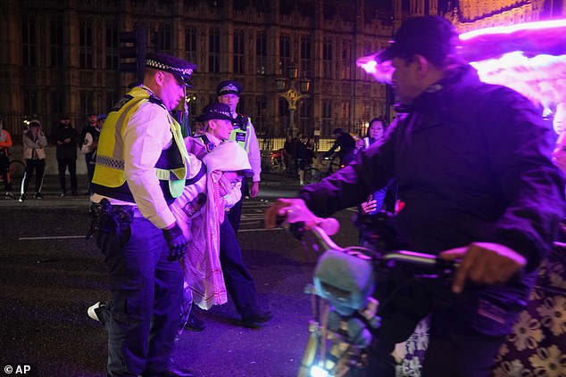 A Palestinian supporter is escorted away by police during a protest in London