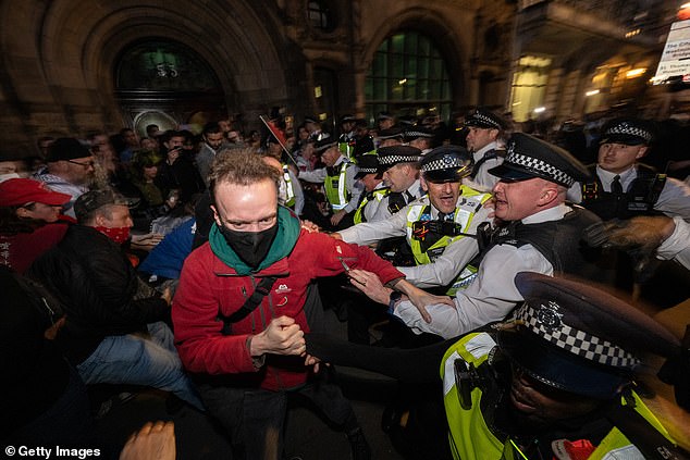 Met Police officers have been seen scuffling with protesters, some of whom wore face masks and scarves, outside Westminster