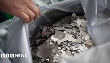 A person's hand holds open a bad of the rare earth element neodymium, which is used for producing permanent magnets.