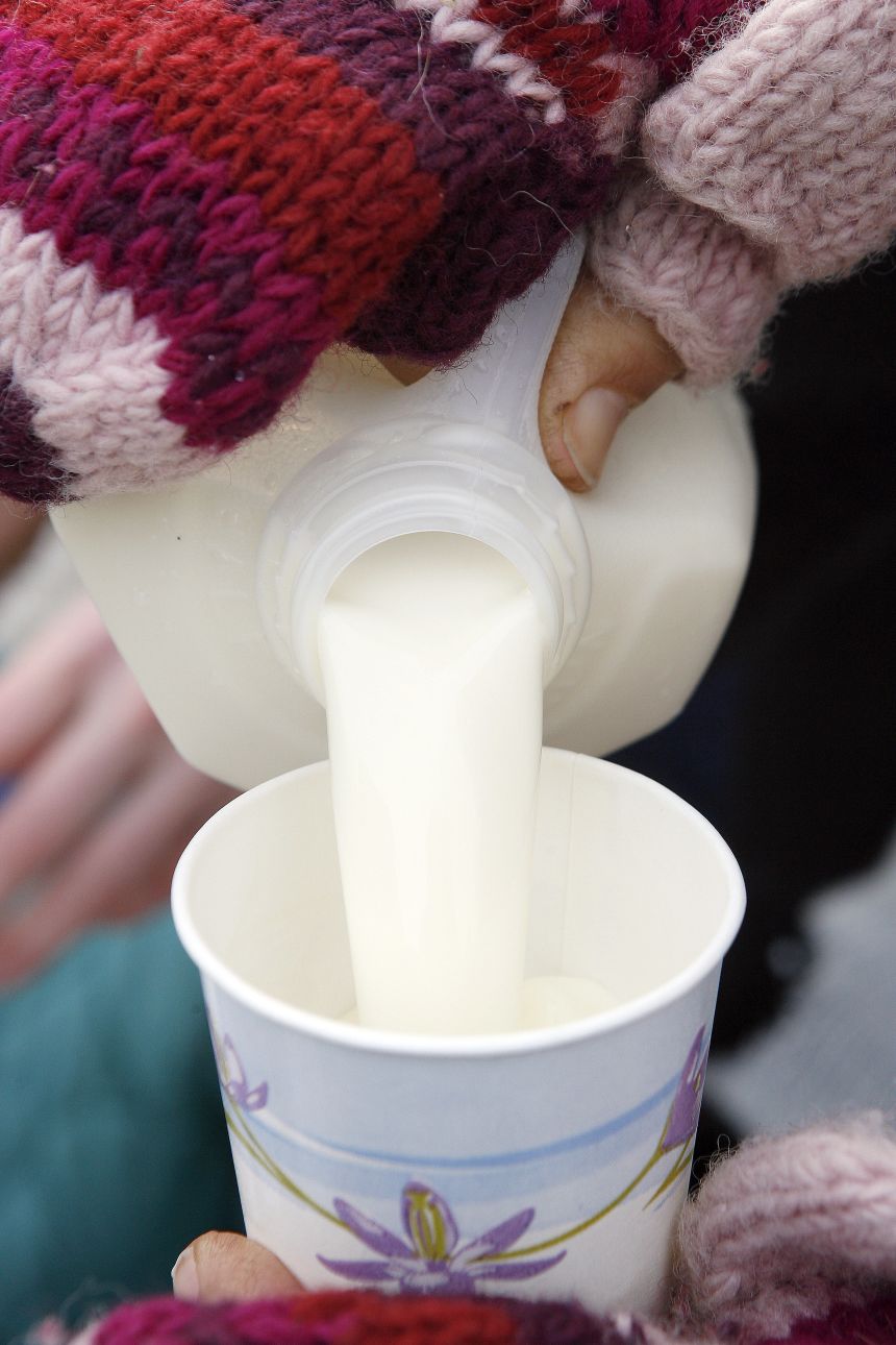 A woman pours a cup of raw milk for a child during a protest in Chicago.