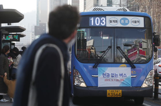 A bus displaying a banner reading “Cashless Bus” operates near a bus stop in Jongno District, central Seoul, on March 1, 2023. Starting that day, the Seoul Metropolitan Government expanded its cashless bus program from 18 routes with 436 buses to 108 routes with 1,876 buses. [NEWS1]