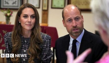 William and Kate sat down facing an elderly woman who is talking to them.