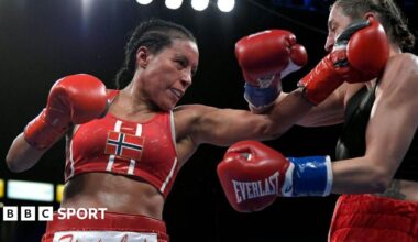 Cecilia Braekhus punches her opponent, wearing the Norway flag on her fight top