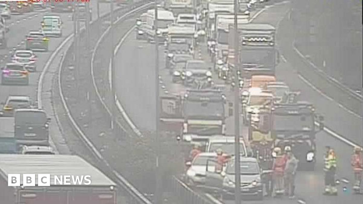 Emergency services seen on scene, with a number of vehicles which appear to have been in collision and traffic queuing behind