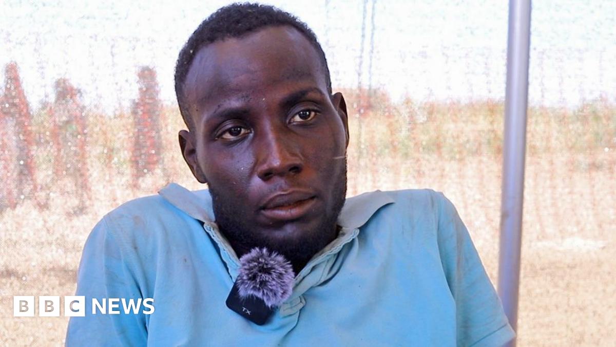 A head and shoulders shot of man in a light blue shirt. He has a clip mic attached to a collar.