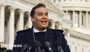 George Santos speaking into microphones out the front of the Capitol building.