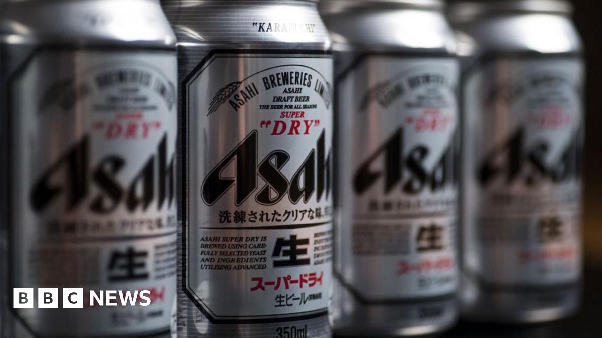 Four silver cans of Asahi beer displayed on a shelf