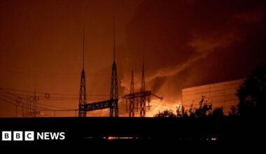 A long shot of a power lines in front of a bright orange blaze