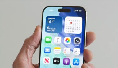 A person holding an iPhone running iOS 26.