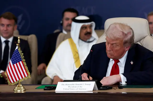 U.S. President Donald Trump signs the agreement at a world leaders' summit on ending the Gaza wa