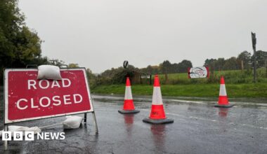 a road closed sign on a wet road
