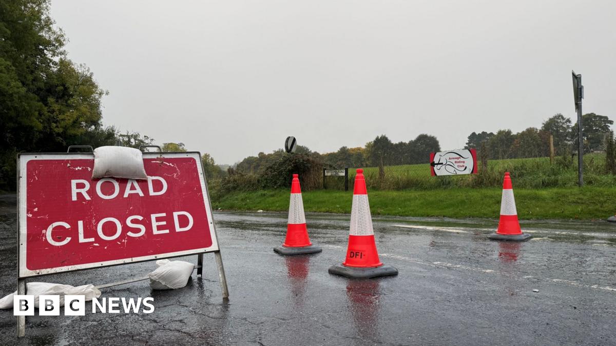 a road closed sign on a wet road