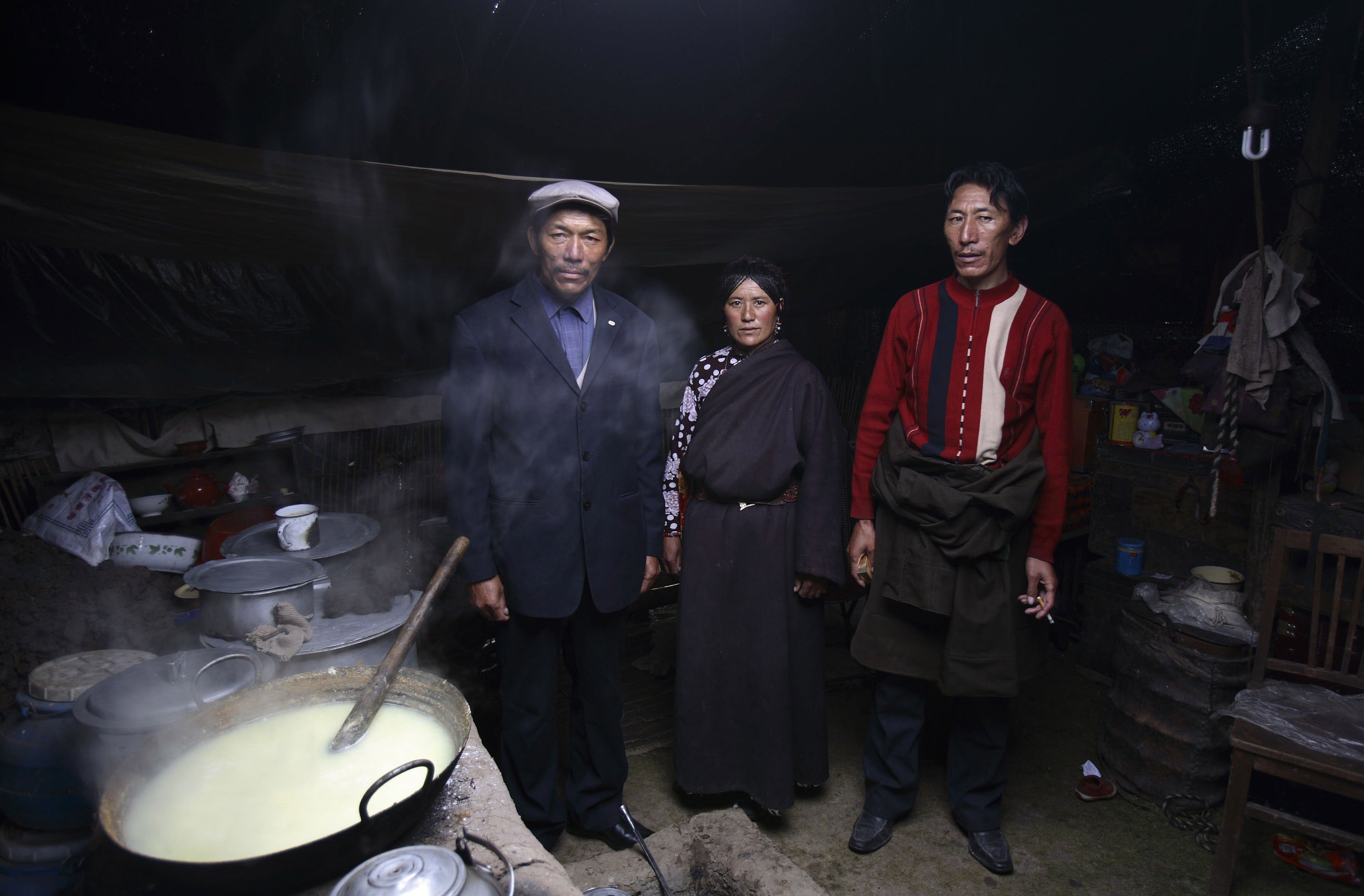 Tibetan man Gama Sangding poses for a photo with his elder brother La Wen and their common wife Cai Zhuo, in their tent at the Burong Village on 18 July 2007