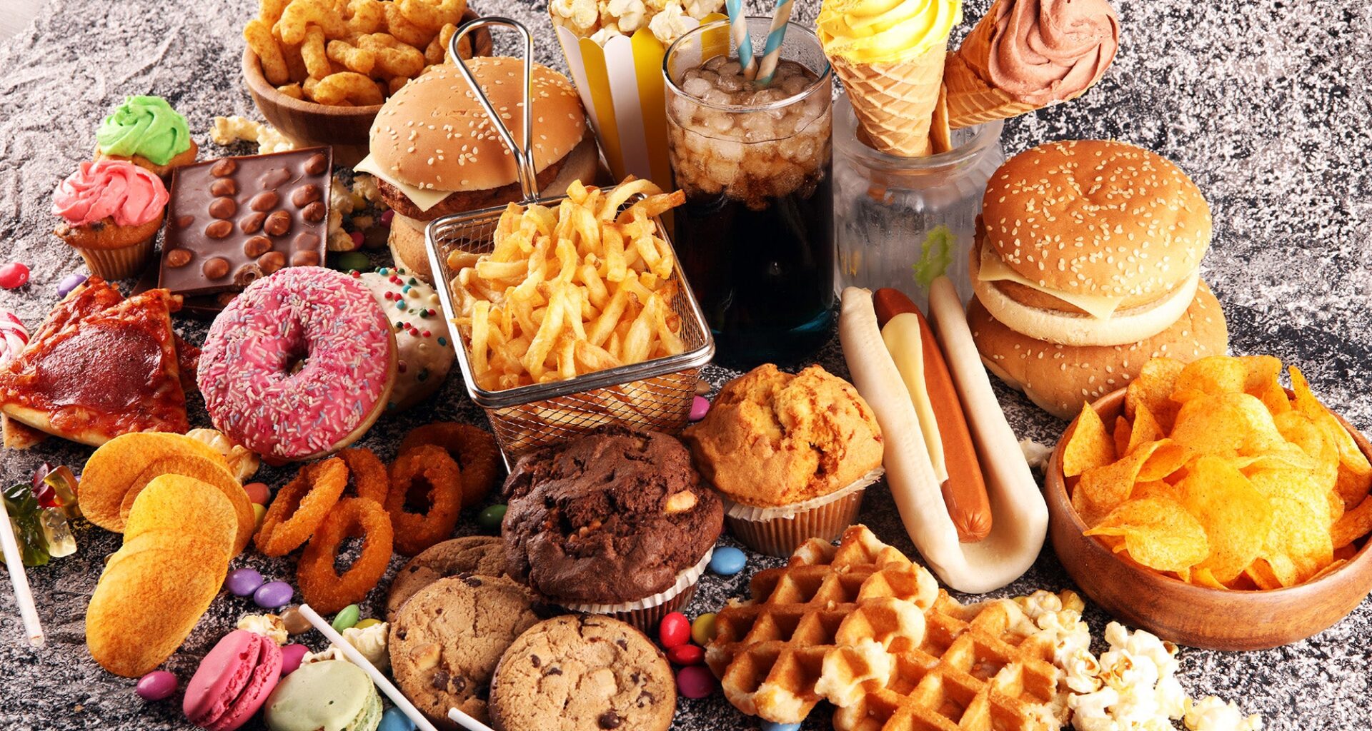 Unhealthy foods—burgers, hot dogs, fries, waffles, doughnuts, cookies, potato chips, etc.