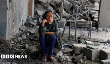 A Palestinian girl sits amid debris at a school in Gaza City's Zeitoun neighbourhood, where displaced people were taking shelter, after it was hit in an overnight Israeli strike (1 October 2025)