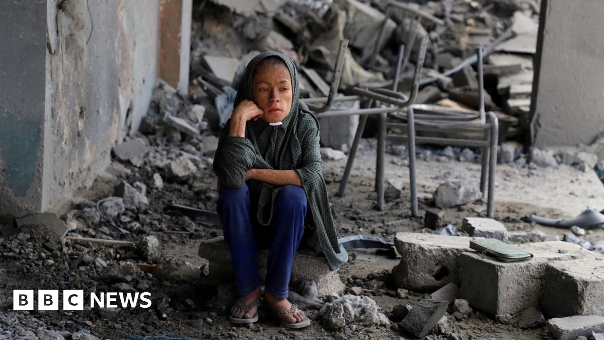 A Palestinian girl sits amid debris at a school in Gaza City's Zeitoun neighbourhood, where displaced people were taking shelter, after it was hit in an overnight Israeli strike (1 October 2025)