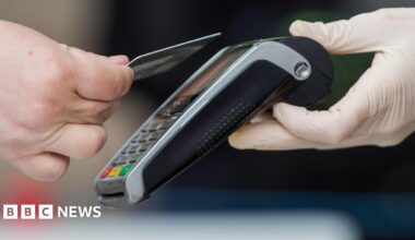 A person tapping their bank card on a card reader.