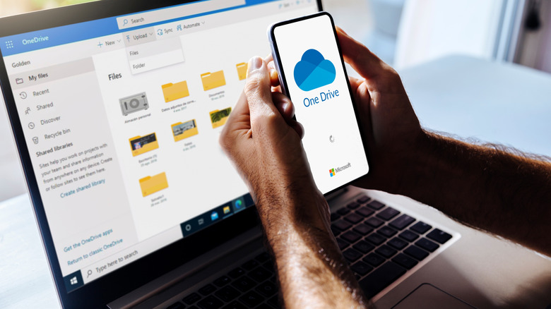 A person using OneDrive on smartphone and PC at once