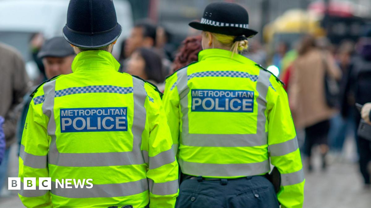 Two police officers are wearing yellow jackets with black hats