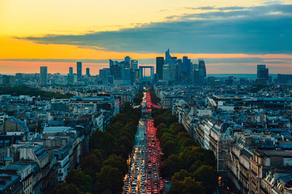 Aerial view of Paris cityscape during evening rush hour along Avenue de la Grande-Armee - view from Arc de Triomphe towards La Defence at sunset.