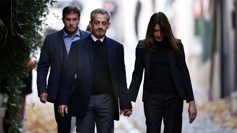 Nicolas Sarkozy leaves his house with his wife Carla Bruni-Sarkozy. Pic: Reuters