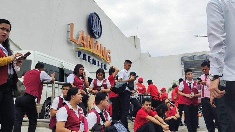 People in Davo City wait outside following the 7.6-magnitude quake. Pic: Getty Images