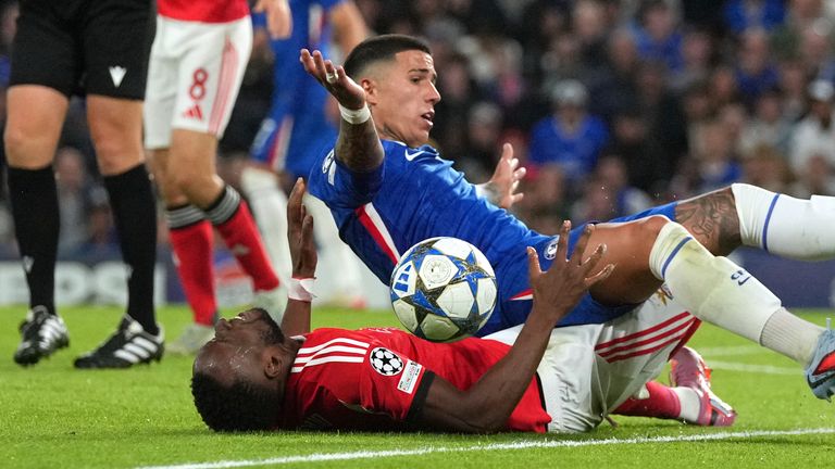 Chelsea's Enzo Fernandez falls on top of Benfica's Dode Lukebakio during a Champions League opening phase soccer match between Chelsea and SL Benfica at Stamford Bridge stadium in London, Tuesday, Sept. 30, 2025. (AP Photo/Kin Cheung)