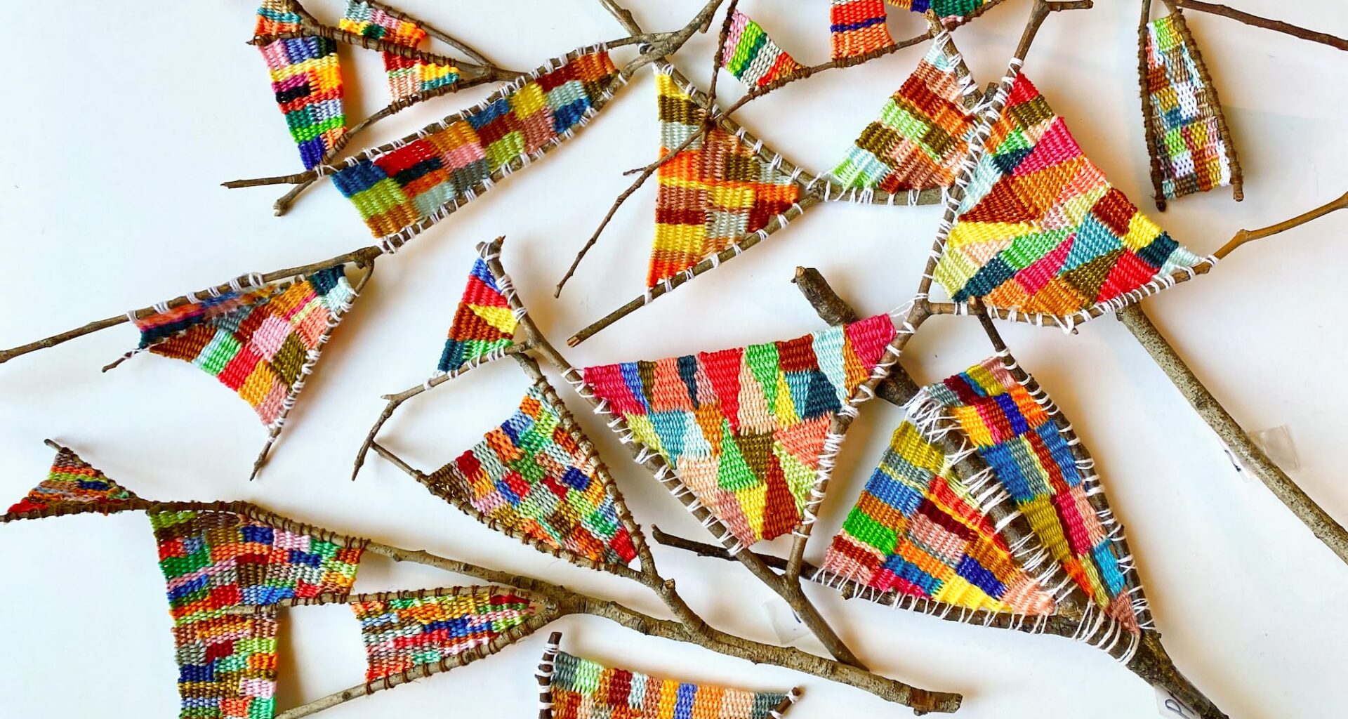 a collection of wish bones with colorful fiber woven between the bones by Kaci Smith