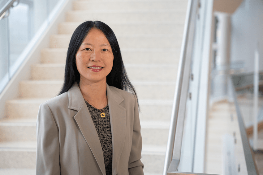 Zhiping Weng, a computational biologist, wears a light grey suit jacket and stands in front of a staircase in a headshot photo. Zhiping Weng, a computational biologist, wears a light grey suit jacket and stands in front of a staircase in a headshot photo.