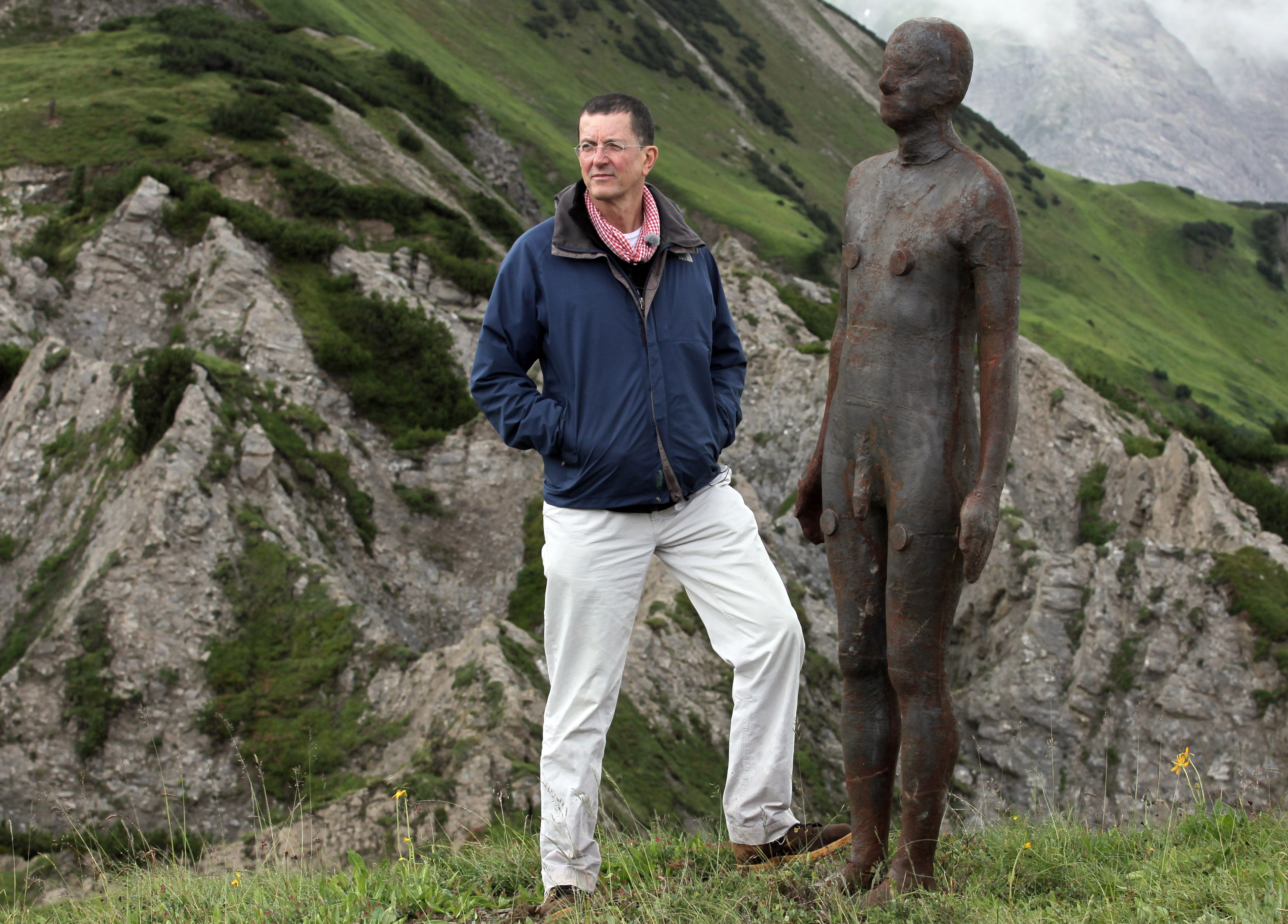 Antony Gormley with a life-sized bronze figure in the Austrian Alps.