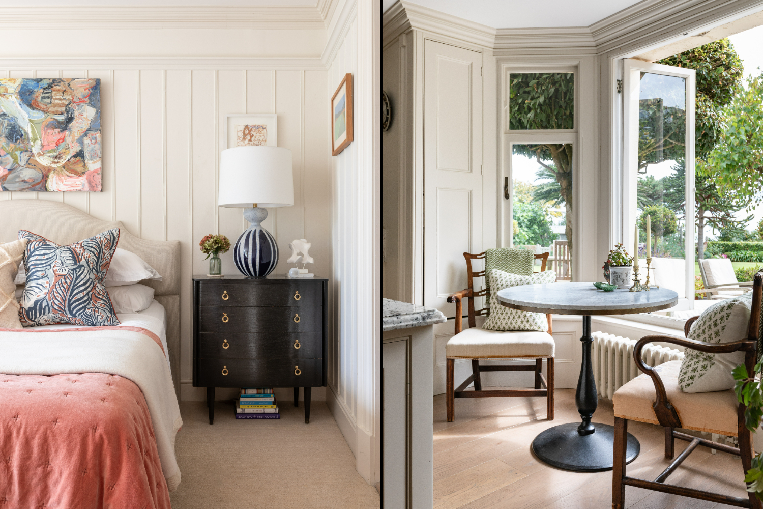 A bedroom with a pink bedspread and a sitting area with a round table and chairs by a window overlooking a garden.