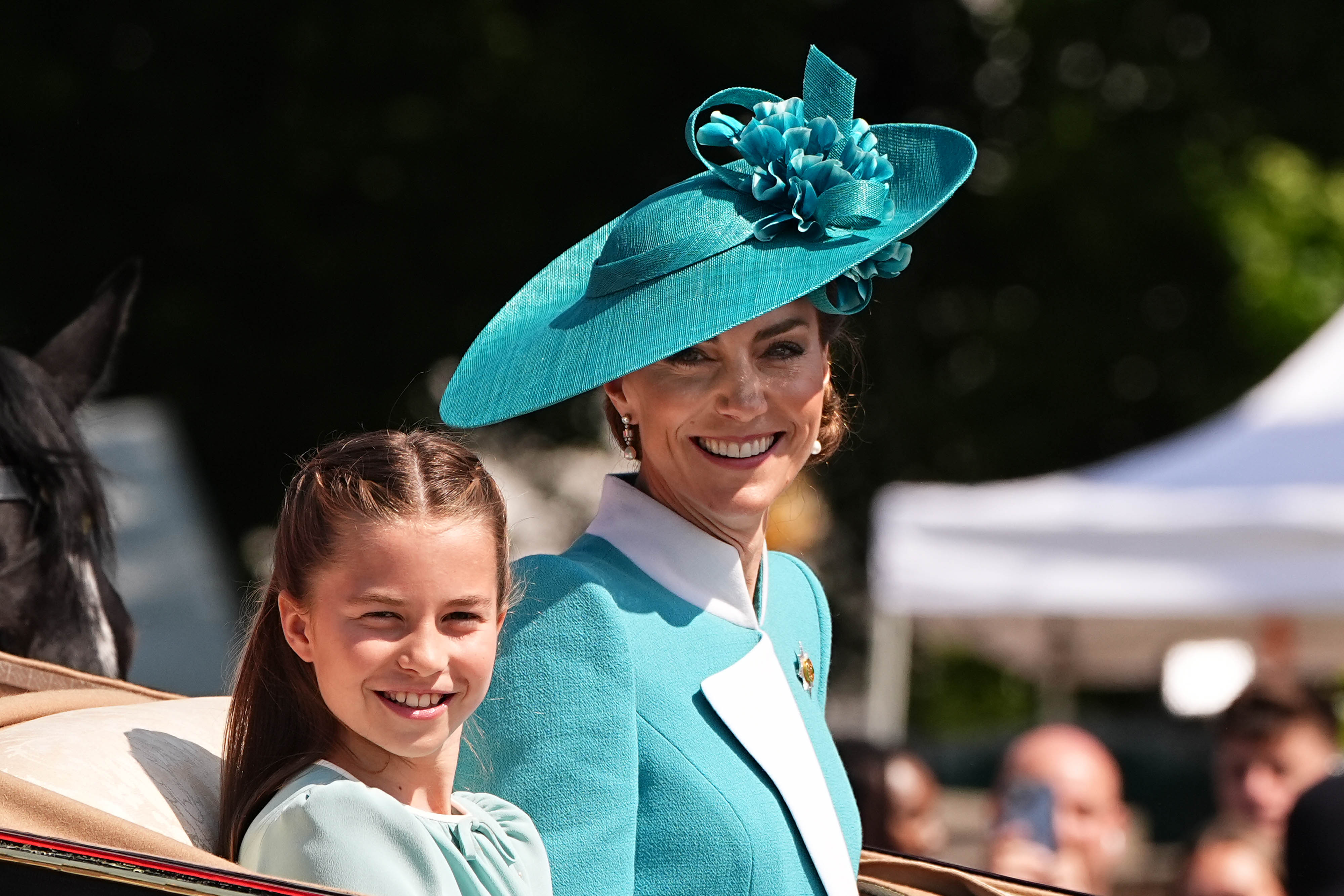 Princess Charlotte and the Princess of Wales smiling in a carriage during Trooping the Colour ceremony.