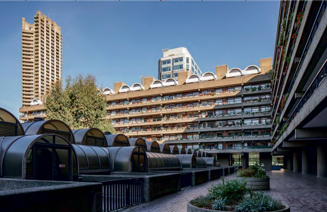 A courtyard in Barbican complex with a tall building and Brutalist style apartment buildings.