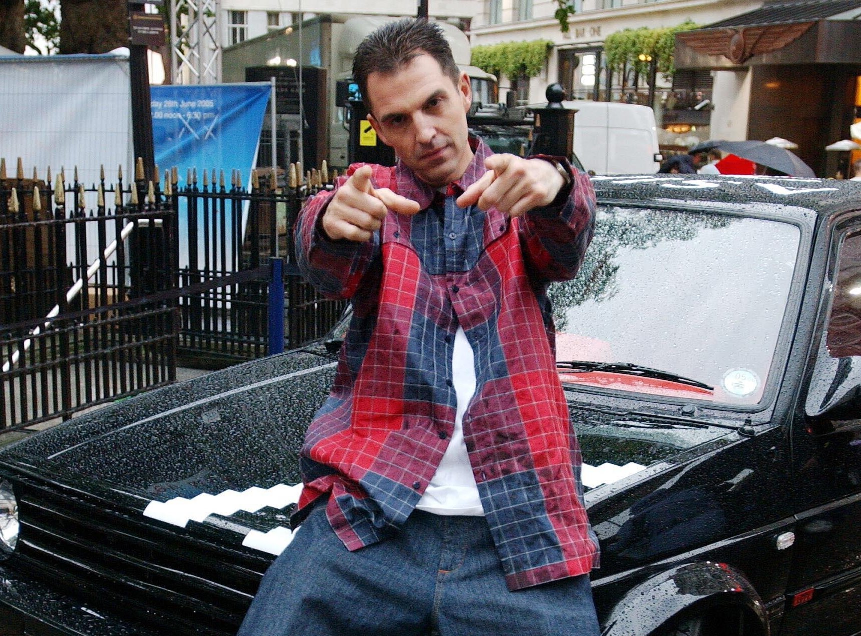 DJ Tim Westwood posing in front of a black car.
