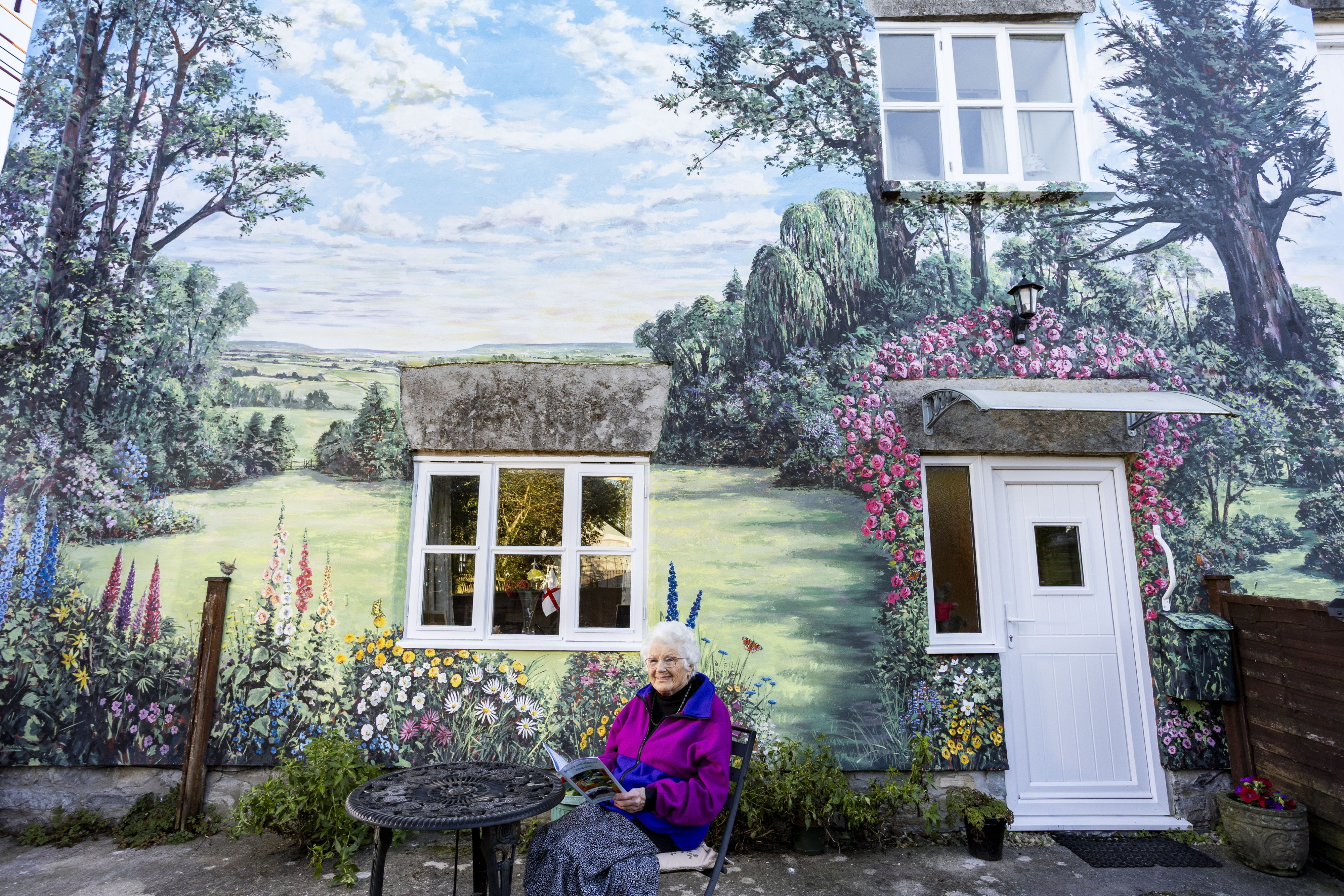 Woman who can't manage to look after a garden gets one painted on her house