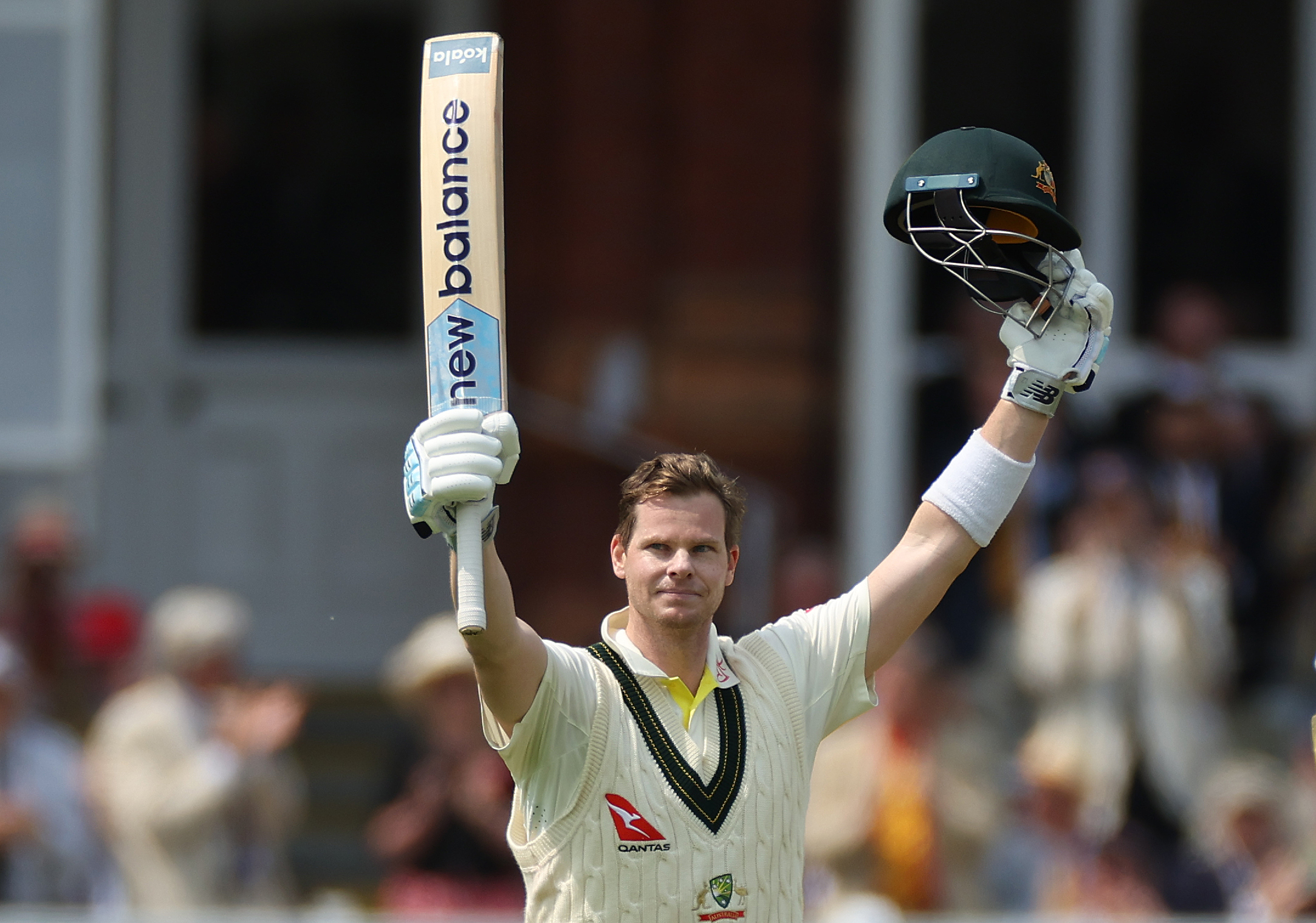 Steve Smith celebrating his test century, holding up his bat and helmet.