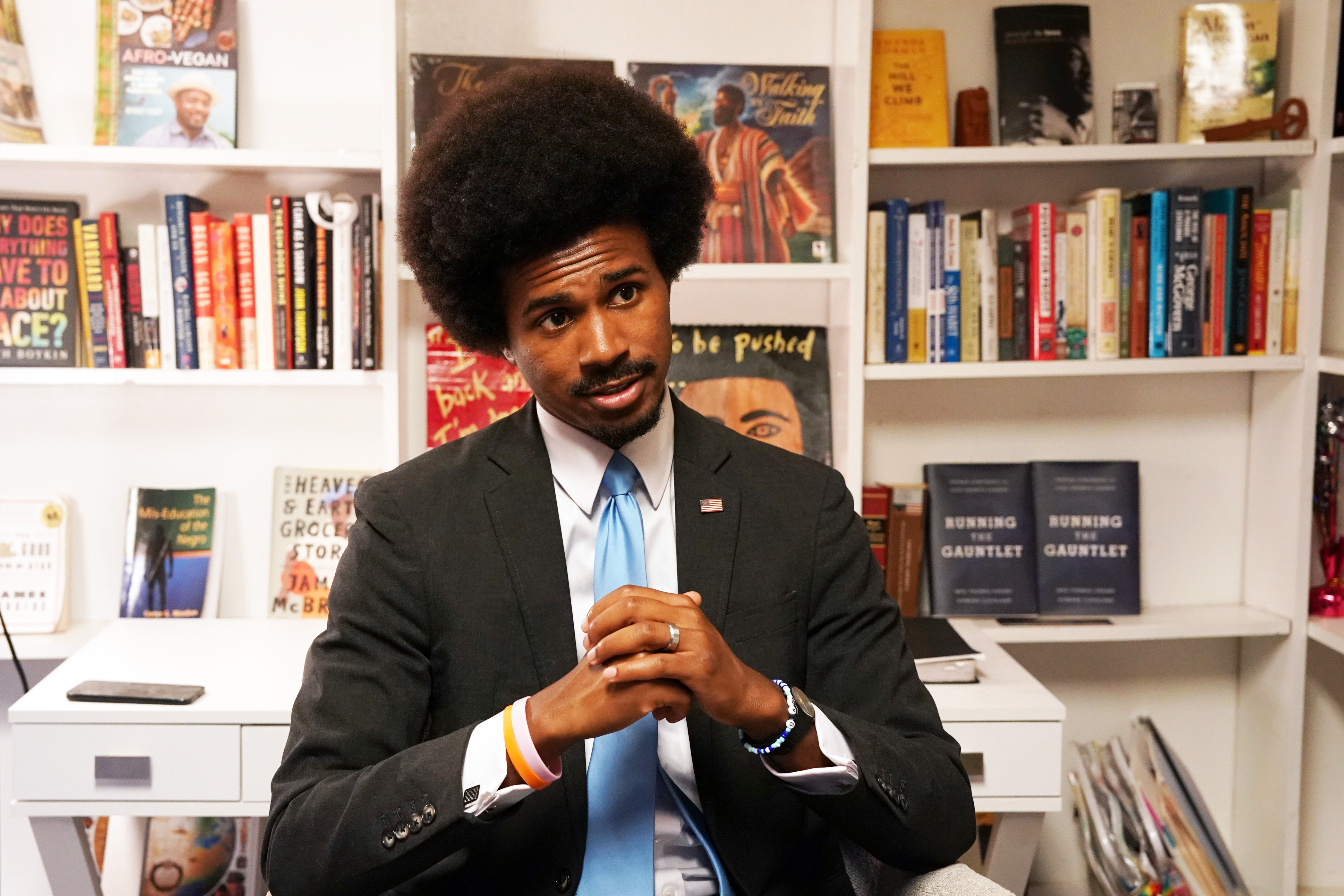 Rep. Justin Pearson sitting in front of a bookshelf with his hands clasped.