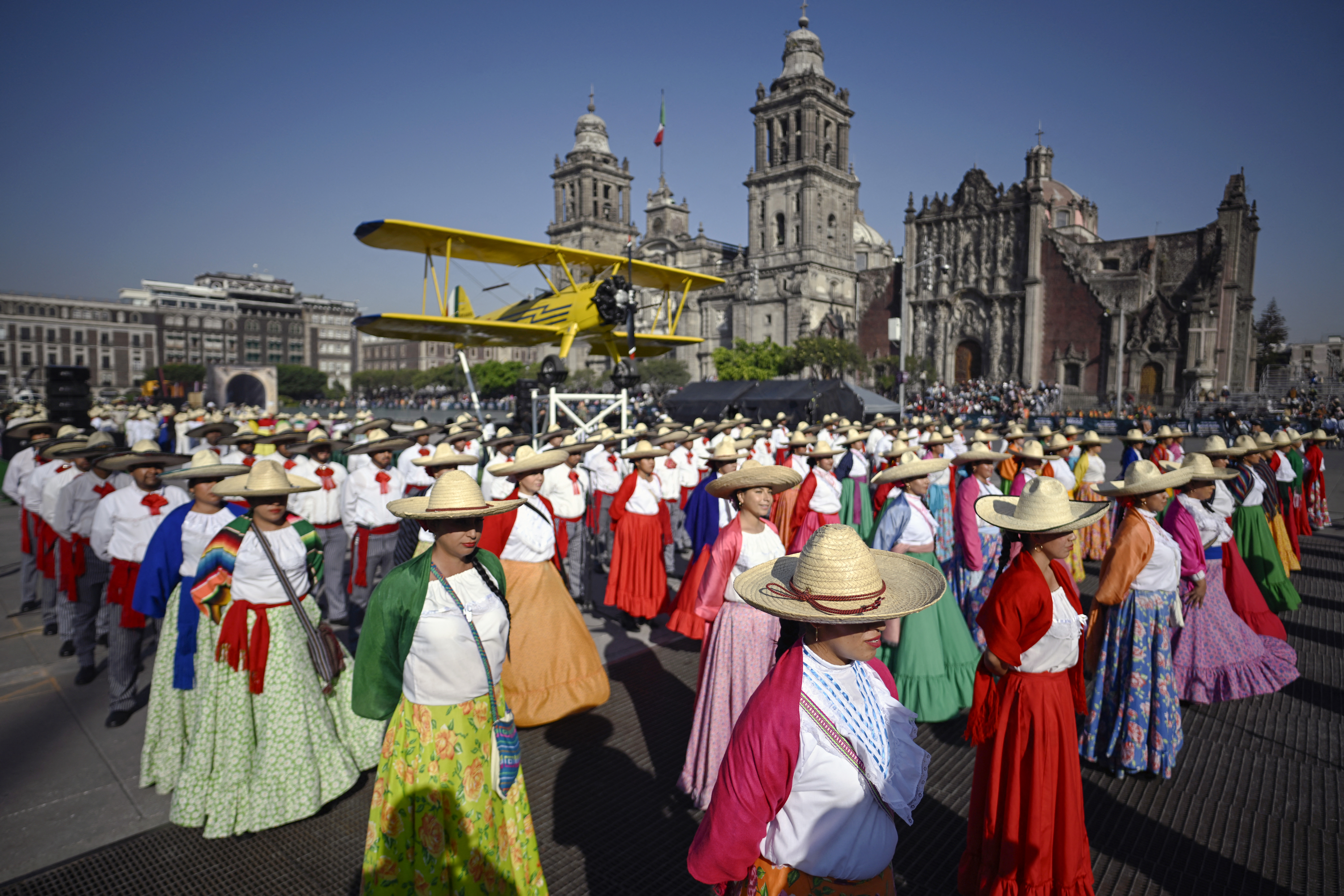 Actors in traditional attire parade at Zócalo Square for the 115th anniversary of the Mexican Revolution.