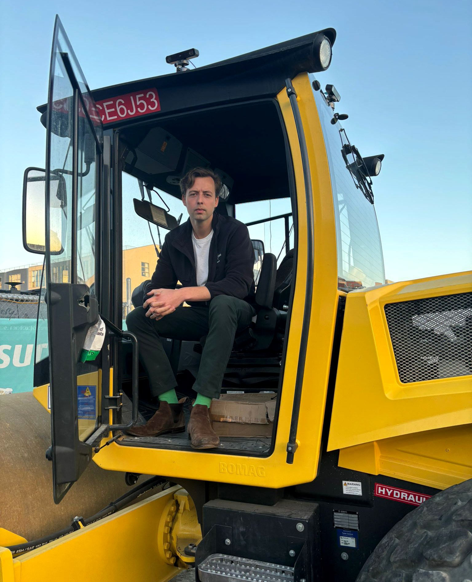 Frederik Filz, CEO of Crewline, sits in the cab of a yellow construction vehicle equipped with vision kits for autonomous operation.