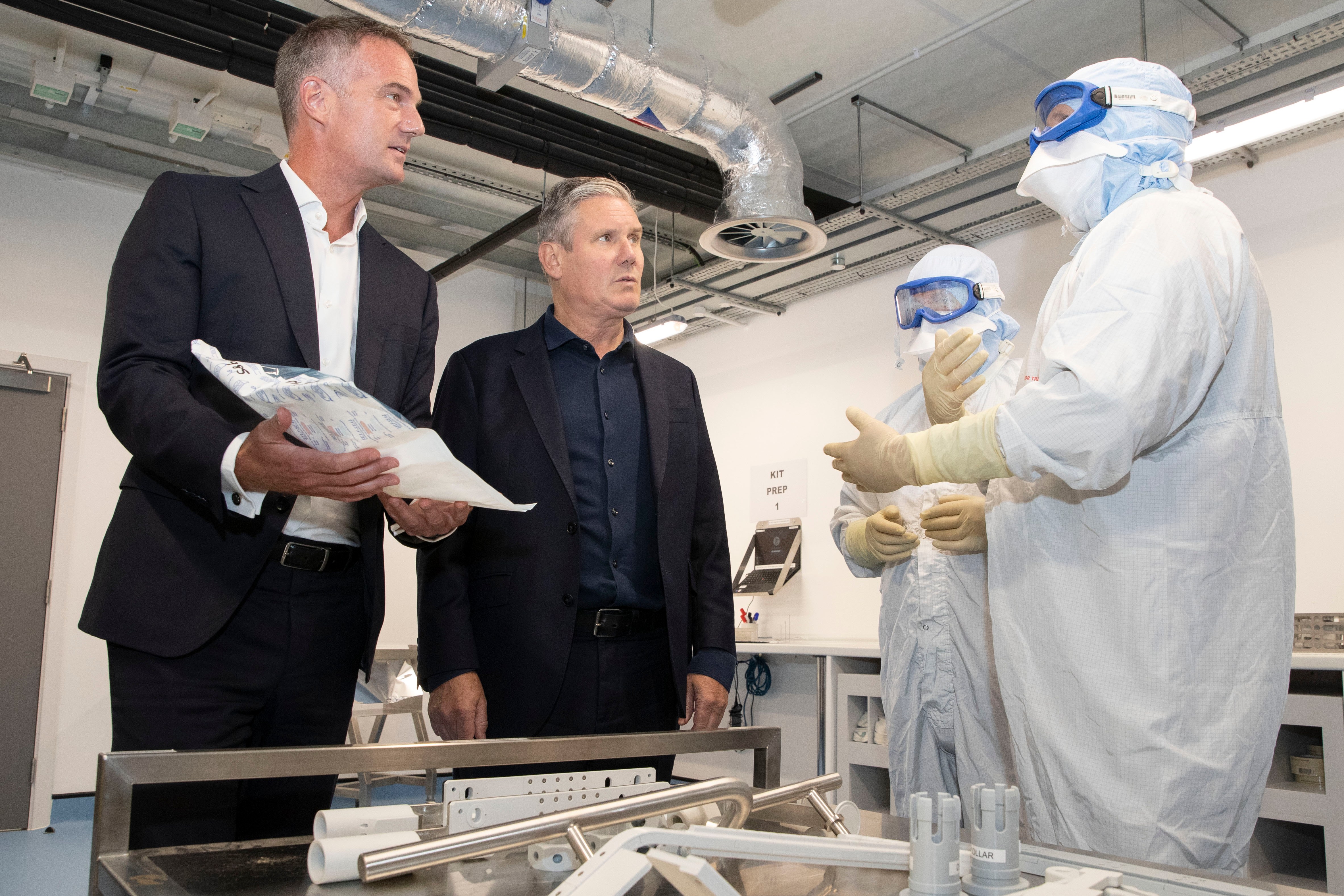 Keir Starmer and Peter Kyle speaking with two AstraZeneca employees in a laboratory cleanroom.
