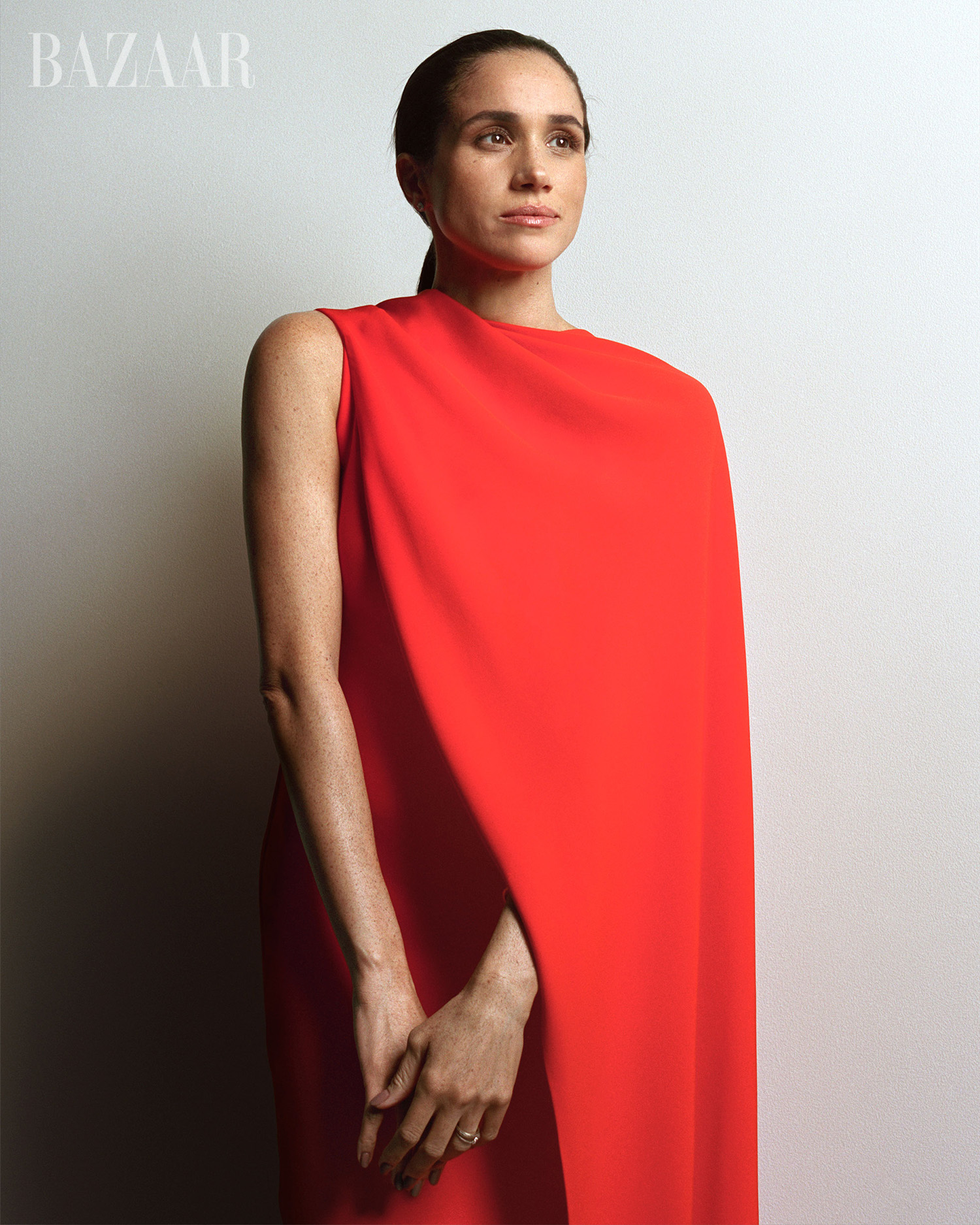 Meghan Markle, Duchess of Sussex, on the cover of Harper's BAZAAR's December 2025/January 2026 Art Issue, wearing a red dress.
