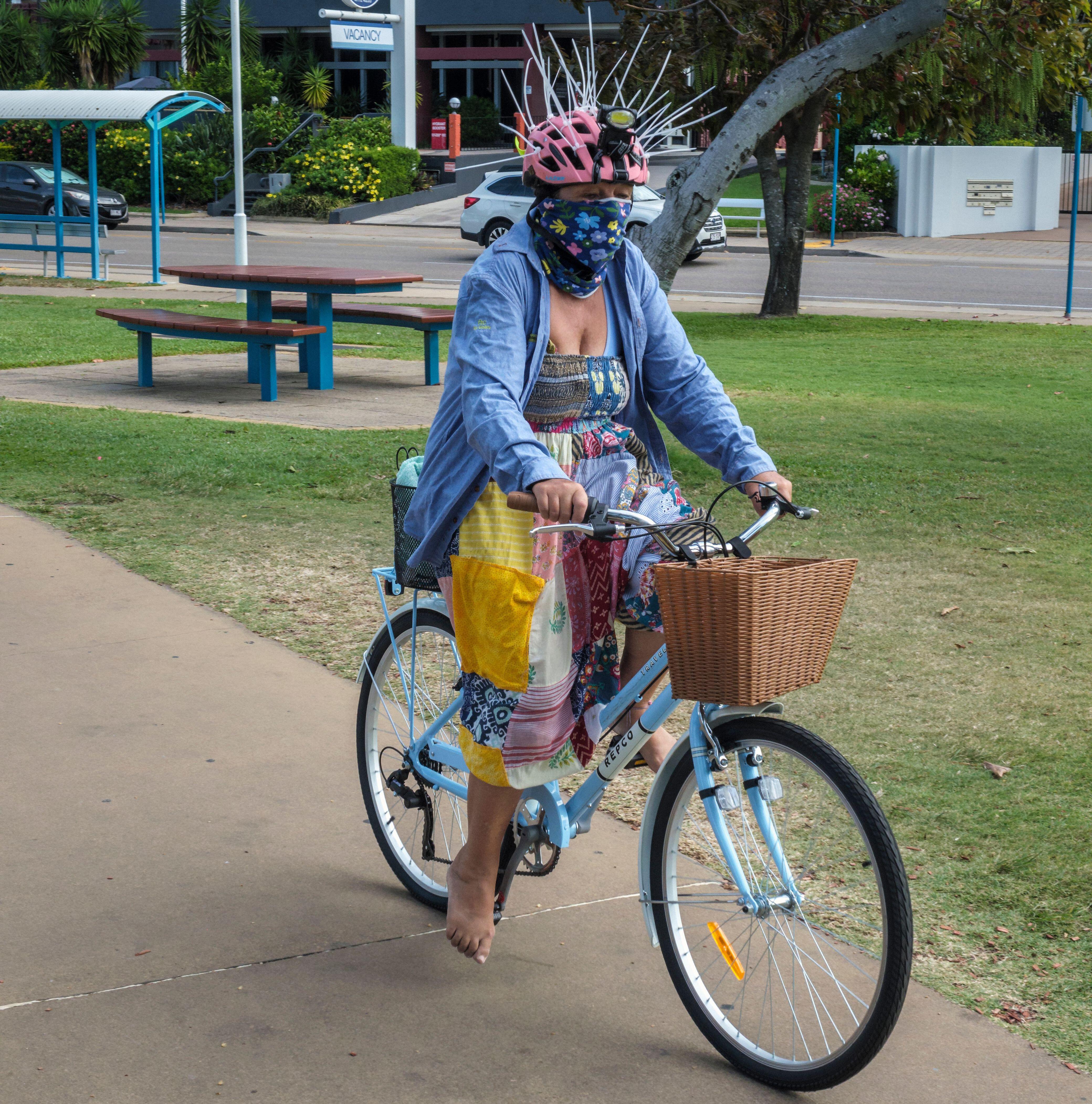 A cyclist wearing a helmet with spikes to deter magpies.