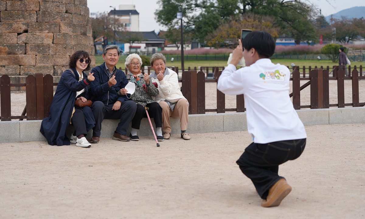 A volunteer assists local residents with taking photos during the 2025 APEC Economic Leaders’ Meeting. Photo: Zou Zhidong/GT
