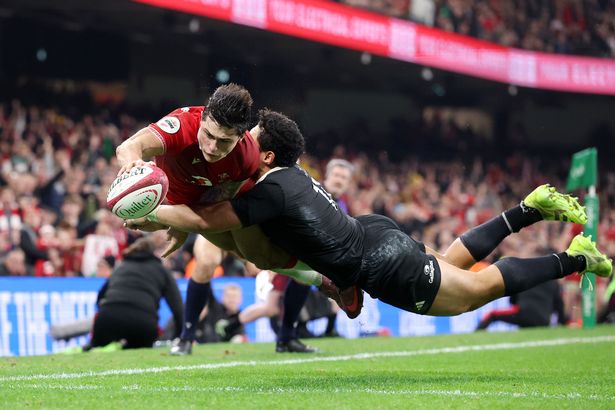 Louis Rees-Zammit of Wales scores his team's fourth try whilst being tackled by Caleb Clarke