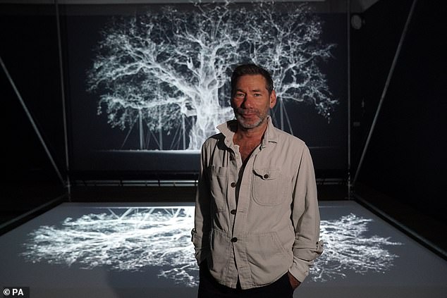 Artist Mat Collishaw, who specialises in AI, has previously had a mural displayed above the centre (pictured with one of his AI pieces)
