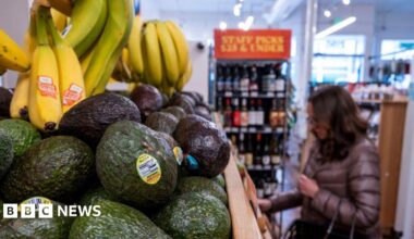 Avocados and bananas at grocery store in San Francisco, California, US, with someone in a puffer coat in the background