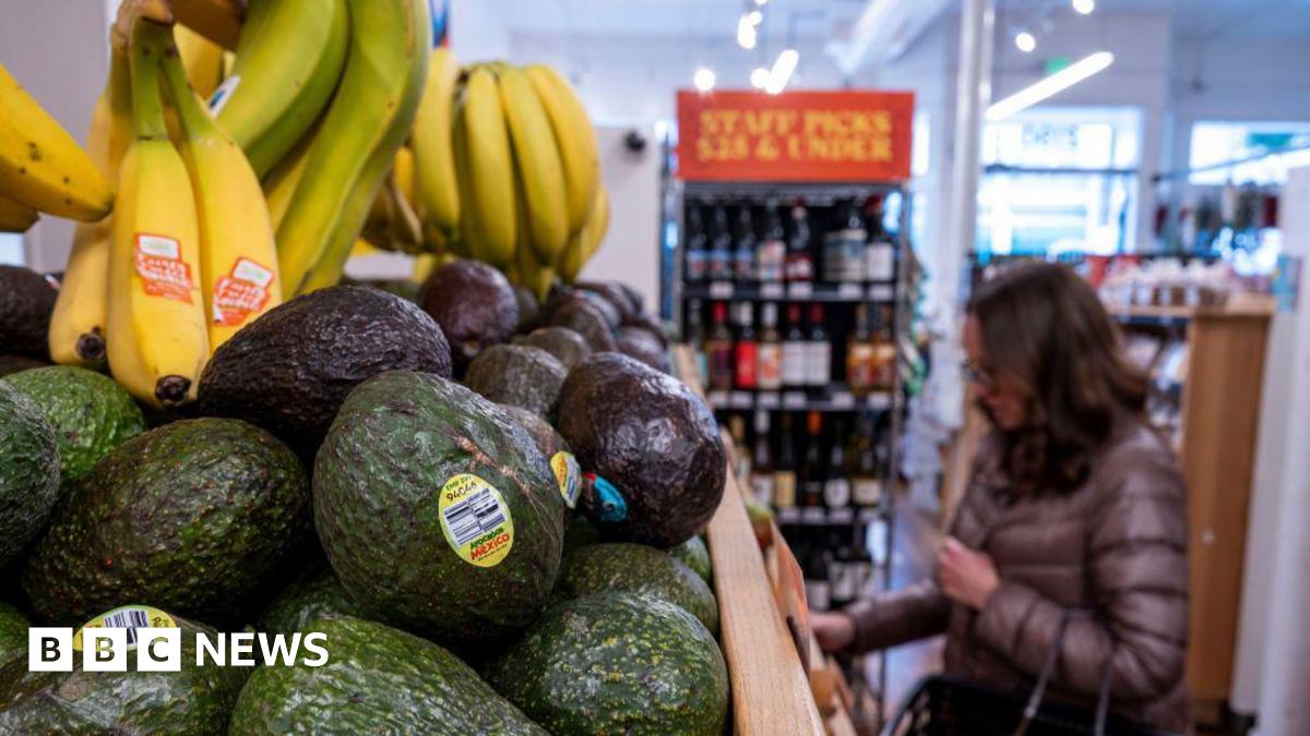 Avocados and bananas at grocery store in San Francisco, California, US, with someone in a puffer coat in the background