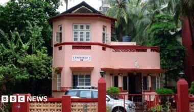 The pink facade of the Saudades art deco-style family bungalow, built in 1936 in Mumbai's Bandra suburb, features local elements like lattice balcony screens.